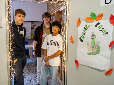 Schüler stehen im Türrahmen geschmückt mit Lichterkette