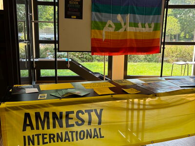 Bunte Fahne und gelber Banner "Amnesty International"